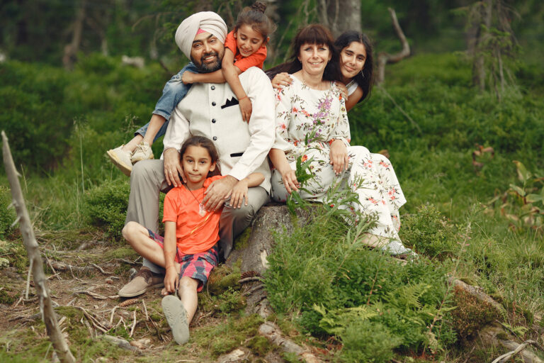 Indian man in a forest. Male in a traditional turban. International family in a summer forest.